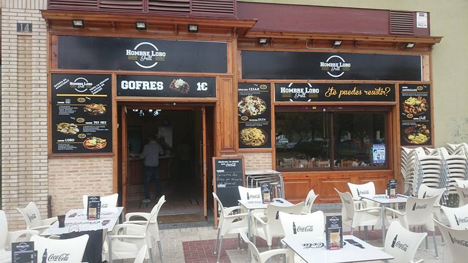 Fachada de restaurante terminada con rótulos, toldo y terraza